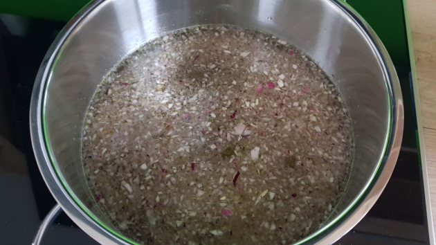 Wasser in einem Topf mit Zwiebel und Ankerkraut-Gewürzmischung.