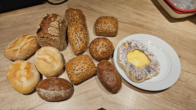 Brot, Brötchen und ein Plunderstück auf einem Tisch.